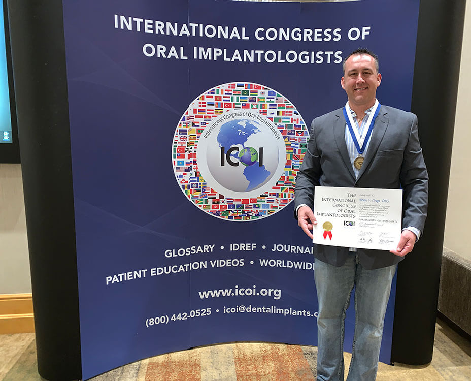 Dr. Croupi, holding an award from the International Congress of Oral Implantologists
